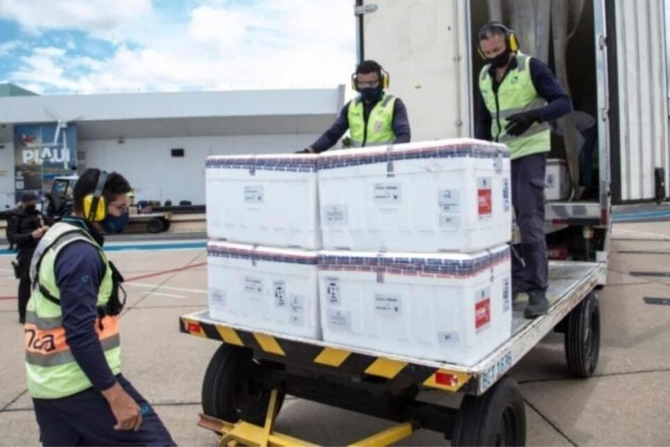 Desembarque de caixas de isopor com vacinas em cima de um carrinho em aeroporto