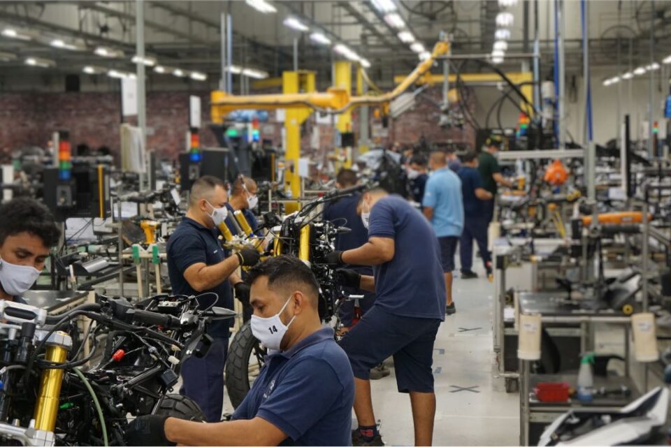 Operários atuando na produção de motocicleta em fábrica brasileira.