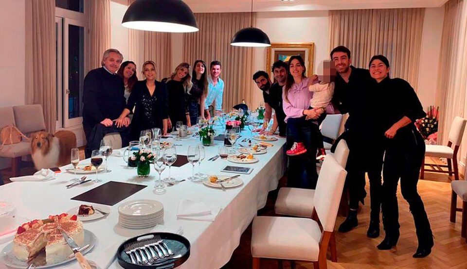 grupo de pessoas reunidas em mesa de jantar
