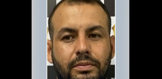 Homem em frente ao painel da Polícia civil