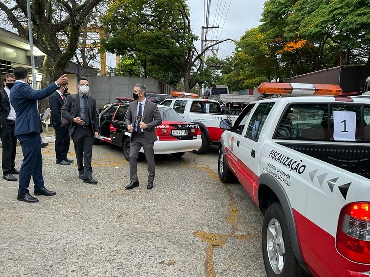 carros da fiscalização estacionados com funcionários ao redor