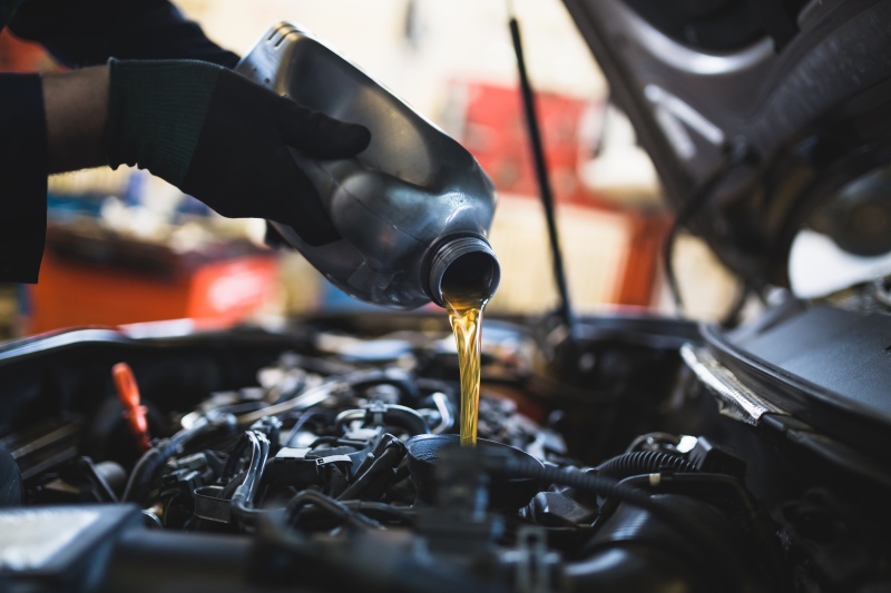Óleo lubrificante sendo colocado em motor de um veículo.